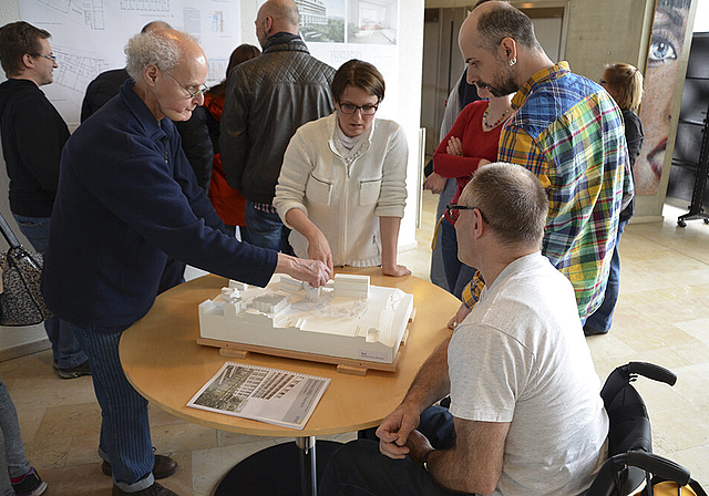 Begutachten das Modell: Mitarbeiter und Bewohner des Wohn- und Bürozentrums für Körperbehinderte (WBZ).  Foto: ZVG