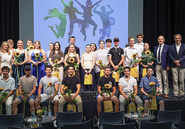 Grosse Erleichterung: Die Absolventinnen und Absolventen strahlen mit den Sonnenblumen um die Wette. Foto: Jan Kriwanek/zVg