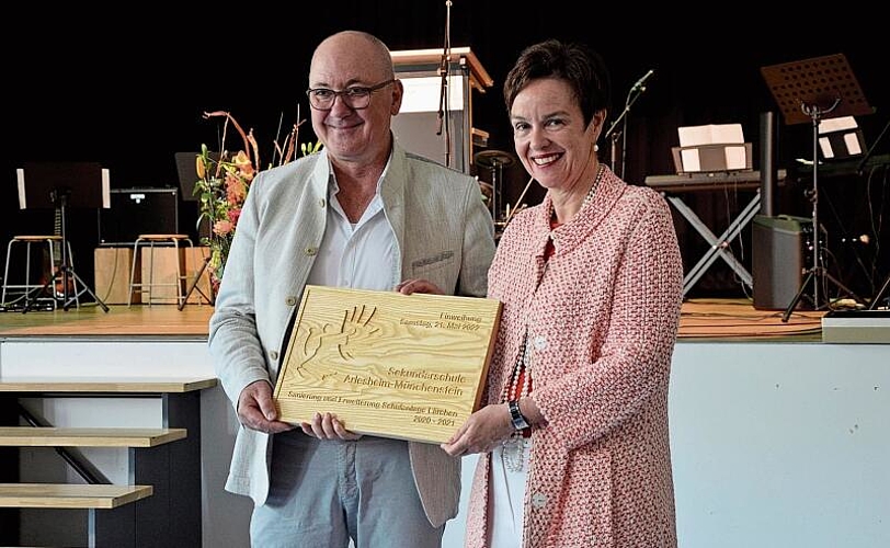 Erinnerung an den Umbau: Bau- und Umweltschutzdirektor Isaac Reber übergibt Bildungsdirektorin Monica Gschwind eine Holztafel zur Einweihung des Lärchen-Schulhauses. Fotos: Jeannette Weingartner
