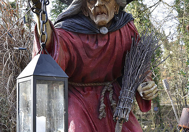 Hexen in Reinach? Auf dieses bilderbuchmässige Exemplar mit Schlapphut, Laterne und Besen trifft man vor dem Restaurant Häxehüsli bei der Reinacher Heide.  Foto: Thomas Kramer