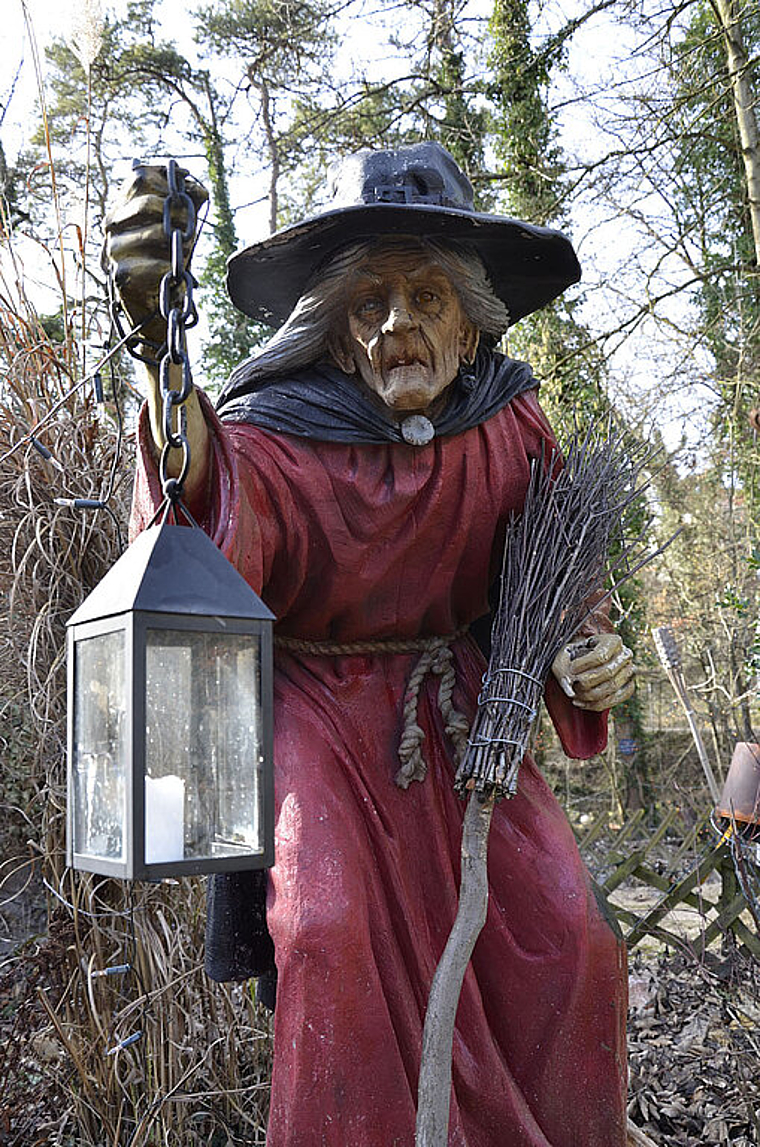 Hexen in Reinach? Auf dieses bilderbuchmässige Exemplar mit Schlapphut, Laterne und Besen trifft man vor dem Restaurant Häxehüsli bei der Reinacher Heide. Foto: Thomas Kramer