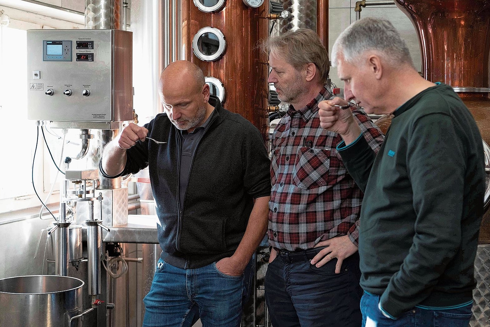 Beim Destillieren: Die «Höllenhund-Gin-Macher» (v. l.) Hans Schneiter, Reto Grossheutschi und Dominik Tschon. Nicht im Bild ist Gabriele Grossheutschi, die ebenfalls zum Team gehört. Foto: zvg