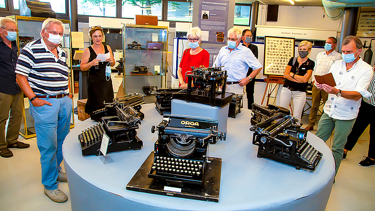 Machte ziemlich viel Lärm: Die ratternde Schreibmaschine im letzten Jahrhundert. Museumspräsidentin Maria Cajochen (ohne Maske), informiert kurzweilig und kompetent. Foto: Martin Staub