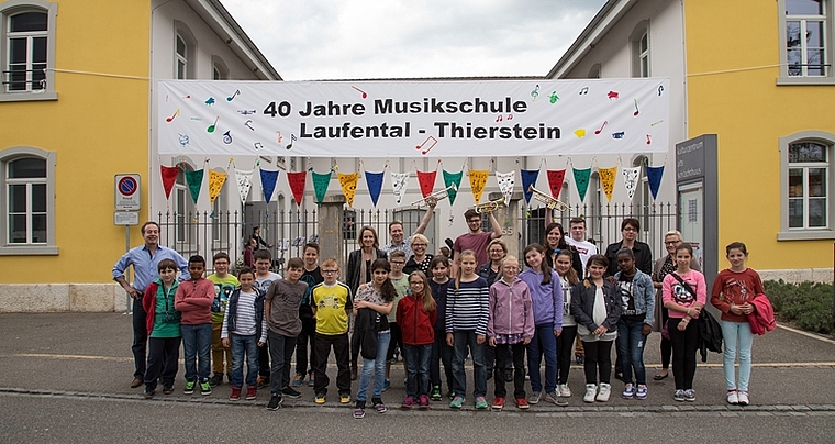 Grund zum Feiern: Die regionale Musikschule hat Geburtstag. Musikschulleiter Ulrich Thiersch (ganz links) freut sich mit dem Team, welches dieses Transparent geschaffen hat. Foto: Martin Staub 