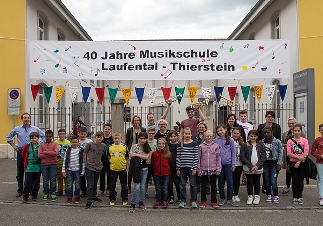 Grund zum Feiern: Die regionale Musikschule hat Geburtstag. Musikschulleiter Ulrich Thiersch (ganz links) freut sich mit dem Team, welches dieses Transparent geschaffen hat. Foto: Martin Staub 