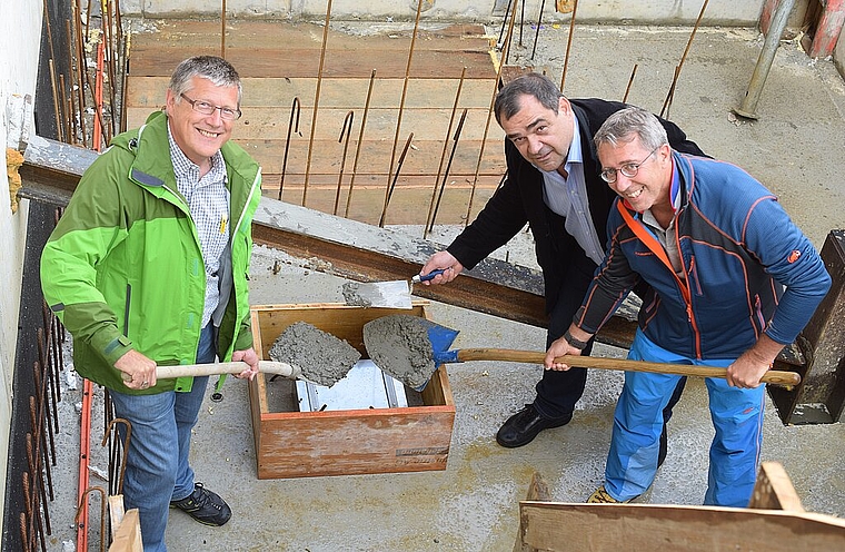 Wer wird die Kiste in Zukunft einmal ausgraben? (v.l.) Baupräsident und Gemeinderat Hugo Bürki, Gemeindepräsident Beat Fankhauser und Gemeindevizepräsident Peter Tschudin betonierten im Fundament Zeitzeugen von heute ein. Foto: Bea Asper