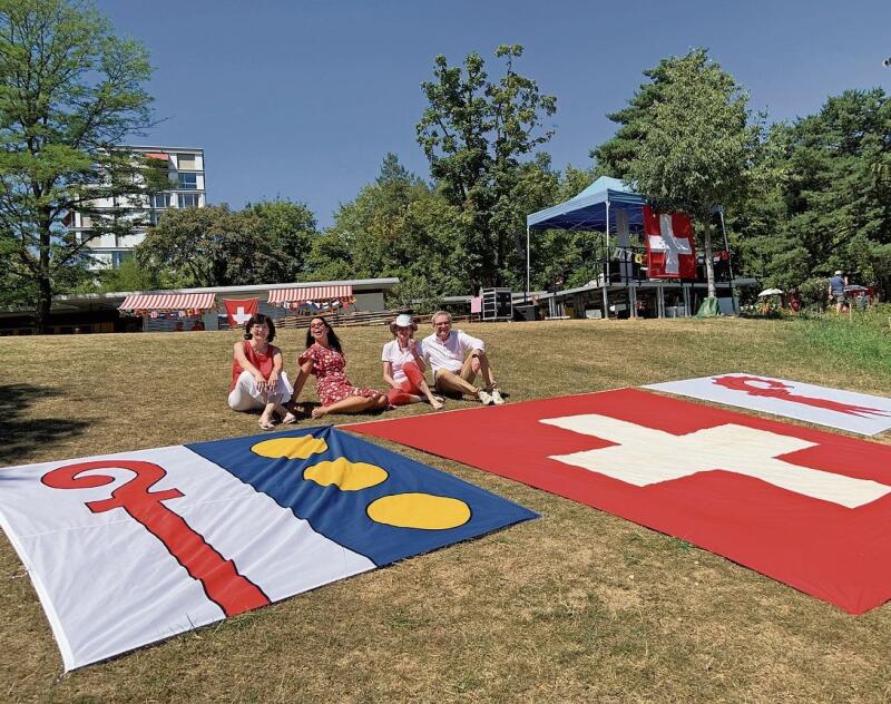 Rot und Weiss dominieren auch hier: Bevor der Gemeinderat ins kühle Nass springt, posiert er vor den Flaggen.