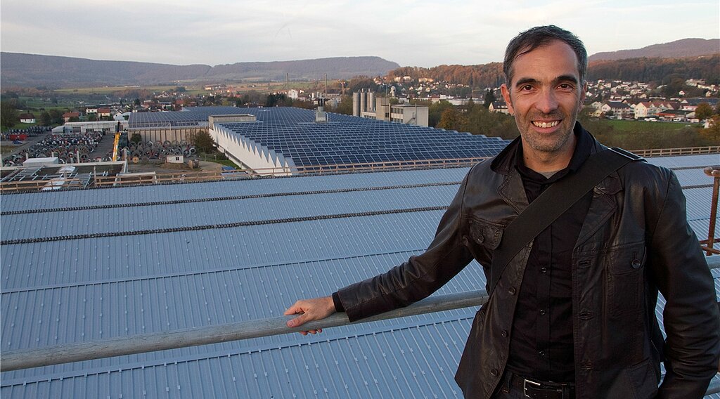 Projektleiter und Produktionsfläche: Vahan Bammerlin freut sich auf die letzte Etappe eines Riesenprojektes. Das Dach im Vordergrund wird in wenigen Wochen auch mit Solarmodulen belegt sein und Strom produzieren. Fotos: Martin Staub
